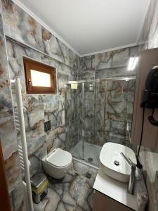 a stone bathroom with a toilet and a shower at Neromylos in Nikísiani +80 photos