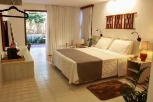 a bedroom with a large bed and a window at Vivá Barra Hotel Pousada in Barra de São Miguel