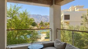 a living room with a couch and a large window at Lake View By Bait Zain in As Sīfah