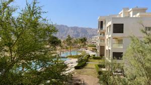 a building with a swimming pool next to a building at Lake View By Bait Zain in As Sīfah +15 photos