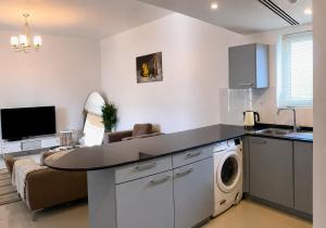 a kitchen and living room with a washing machine at Lake View By Bait Zain in As Sīfah