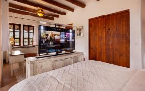 a bedroom with a large screen tv and a bed at Casa Perla de Todos Santos in Todos Santos