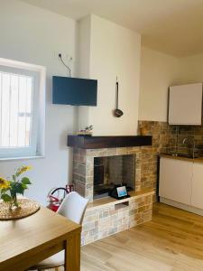 a living room with a brick fireplace and a table at La casina di Viola in Posticciola +9 photos