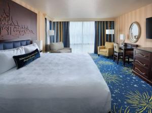 a hotel room with a large bed and a desk at Hotel Rosewood Suites Near Delhi IGI Airport in New Delhi