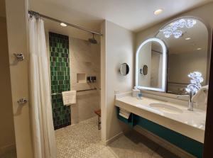 a bathroom with a sink and a shower with a mirror at Hotel Rosewood Suites Near Delhi IGI Airport in New Delhi