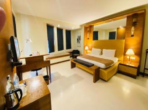 a hotel room with a bed and a desk at Hotel Rosewood Suites Near Delhi IGI Airport in New Delhi