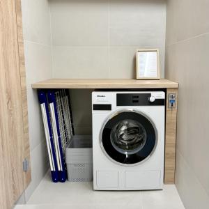 a laundry room with a washing machine and books at Glamping chatky in Spišské Tomášovce