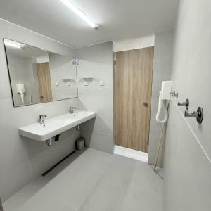 a white bathroom with a sink and a mirror at Glamping chatky in Spišské Tomášovce +11 photos