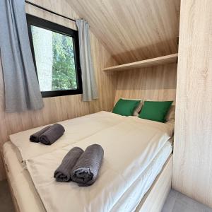 a large bed in a small room with a window at Glamping chatky in Spišské Tomášovce