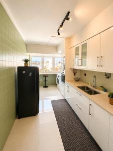 a kitchen with a refrigerator and a sink at Ponte Velha in Peniche