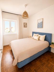 a bedroom with a large bed with a blue headboard at Ponte Velha in Peniche