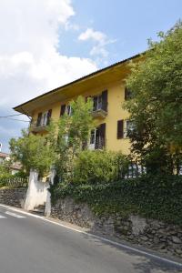 a yellow house on the side of a stone wall at Appartamento Rubiana in Rubiana