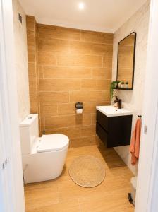 a bathroom with a toilet and a sink and a mirror at Ponte Velha in Peniche +10 photos