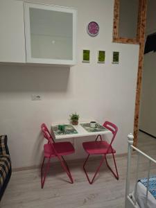 a table and two red chairs in a room at Monolocale Studio Flat in Perugia