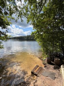a bench sitting on the shore of a lake at Apartment with sauna and fireplace in Viitna