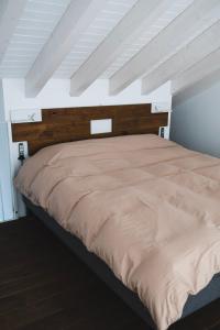 a bedroom with a large bed with a wooden headboard at Vale De Água Equestrian Resort in Odemira
