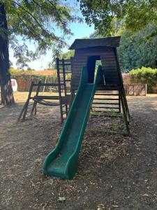 a green slide on a playground in a park at Manoir de la Blonnerie in Vellèches