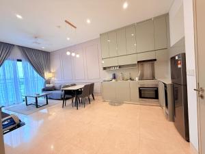 a kitchen and living room with a table and chairs at Lucentia Residence BBCC Modern City View Stay in Kuala Lumpur
