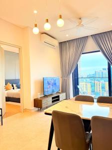 a living room with a dining table and a television at Lucentia Residence BBCC Modern City View Stay in Kuala Lumpur
