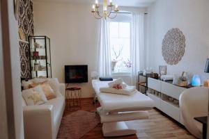 a living room with white furniture and a chandelier at Pension Vila Hana in Loket