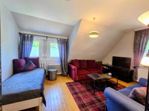 a living room with two couches and a tv at HR Townhouse Honigbach in Coesfeld