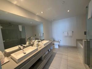 a bathroom with two sinks and a toilet and a mirror at Steps from the Beach - Amazing Views in Hollywood