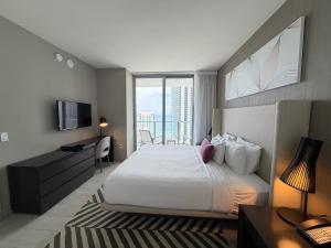 a bedroom with a bed and a desk and a television at Steps from the Beach - Amazing Views in Hollywood +14 photos