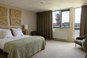 een hotelkamer met een bed en een groot raam bij Forest Hotel in Den Helder +71 foto's