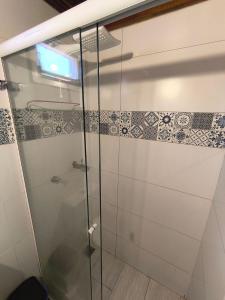 a glass shower in a bathroom with tiles on the wall at Chalé Diamante c /AR in Volta Redonda +12 photos