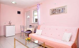 a living room with a pink couch and a table at Vila Mia in Donji Štoj