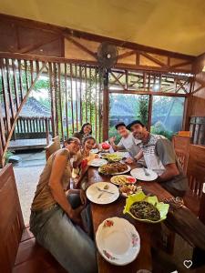 a group of people sitting at a table eating food at Awang Homestay in Bumbang