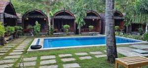 a swimming pool in a yard with a house at Awang Homestay in Bumbang