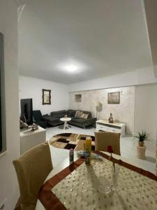 a living room with a table and a couch at Solid House Apartment - Sea View in Mamaia