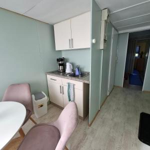 a small kitchen with two chairs and a table at casabandow in Schwaan