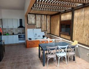 a kitchen with a table and chairs in a kitchen at Art & View Family Jacuzzi Suite with Balcony in Maghār