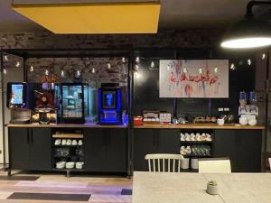 a coffee shop with a counter with a coffee machine at Carré Pau Airport Hôtel in Serres-Castet