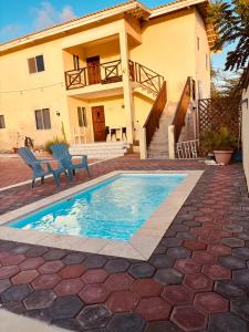 a house with a swimming pool in front of a house at sol appartement 3 in Willemstad +7 photos