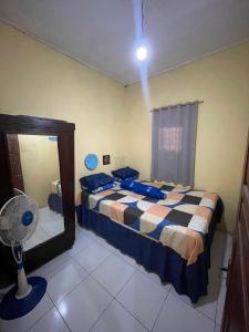 a bedroom with two beds and a fan at Guest House Brahu Syariah in Trowulan