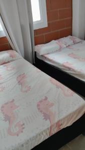 two twin beds in a room with a blanket on them at Cabaña los villa in Necoclí