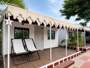 a house with a porch with chairs on a deck at Unity Holiday Resort in Kevadia