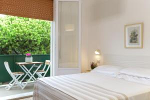 a bedroom with a bed and a balcony with a table at Residence delle Nazioni - Spiaggia privata su richiesta in Principina a Mare