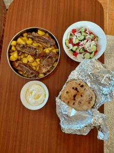 a table topped with food and a bowl of salad at Cozy Lakefront Cabin - Myselim in Shkodër +16 photos