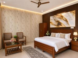 a bedroom with a bed and a couch and a table at Omkara Villa Sonipat in Sonīpat