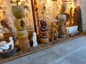 a group of statues sitting next to a wall at Art & View Family Jacuzzi Suite with Balcony in Maghār
