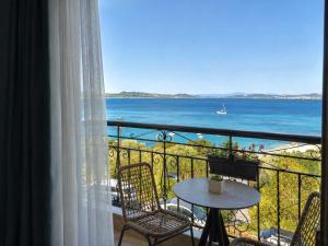 a balcony with a table and chairs and the ocean at Pansion Katerina in Ouranoupoli