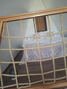 a rope bed in a room with a window at RanyA-Frame in Nucşoara