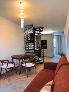 a living room with a couch and a spiral staircase at Apartmán Thea in Komárno