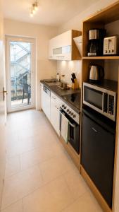 a kitchen with a stove and a microwave at Hinterhaus am Schloss Karlsruhe in Karlsruhe