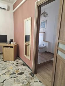 a room with a bathroom with a mirror at Torres House Suite & Rooms in Sassari