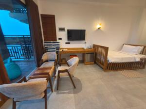 a hotel room with a bed and a desk with chairs at Ananthaya Beach in Tangalle